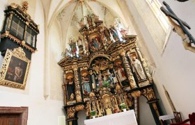 Innenansicht der Wallfahrtskirche Annaberg mit reich verziertem Altar und religi&ouml;sen Statuen.