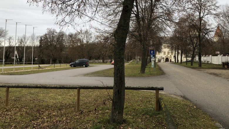 Wohnmobilstellplatz, © Gemeinde Asparn a.d. Zaya Parkplatz mit Bäumen und einem Gebäude im Hintergrund.