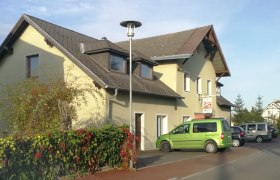 Gasthaus Kern in Prinzersdorf mit geparkten Autos und Laterne.