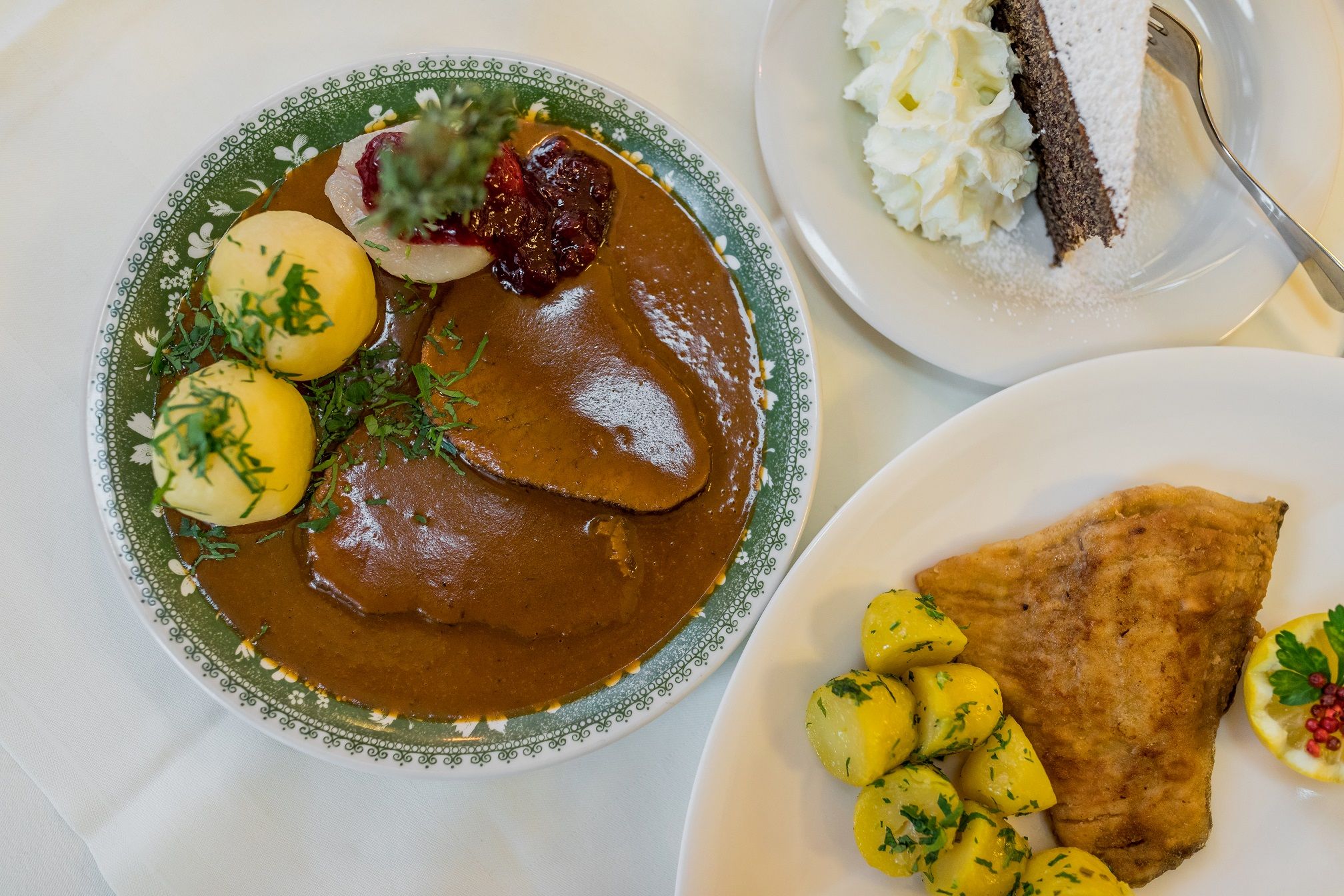 Traditionelles österreichisches Gericht mit Fleisch, Knödeln, Kartoffeln und Kuchen.