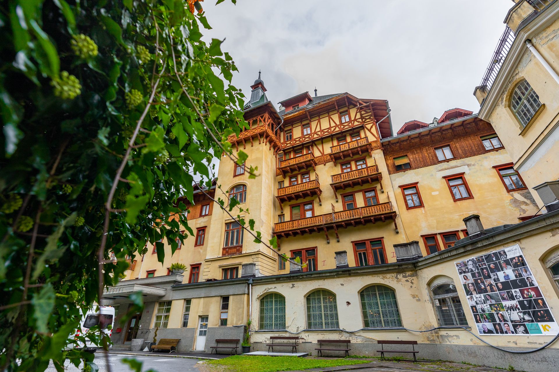 Historisches Gebäude des Südbahnhotels Semmering mit Holzverzierungen und Balkonen, umgeben von grünen Pflanzen.