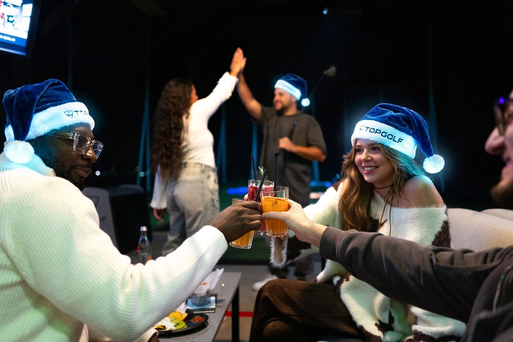 Gruppe von Menschen mit blauen Weihnachtsmützen auf einer gemütlichen Feier