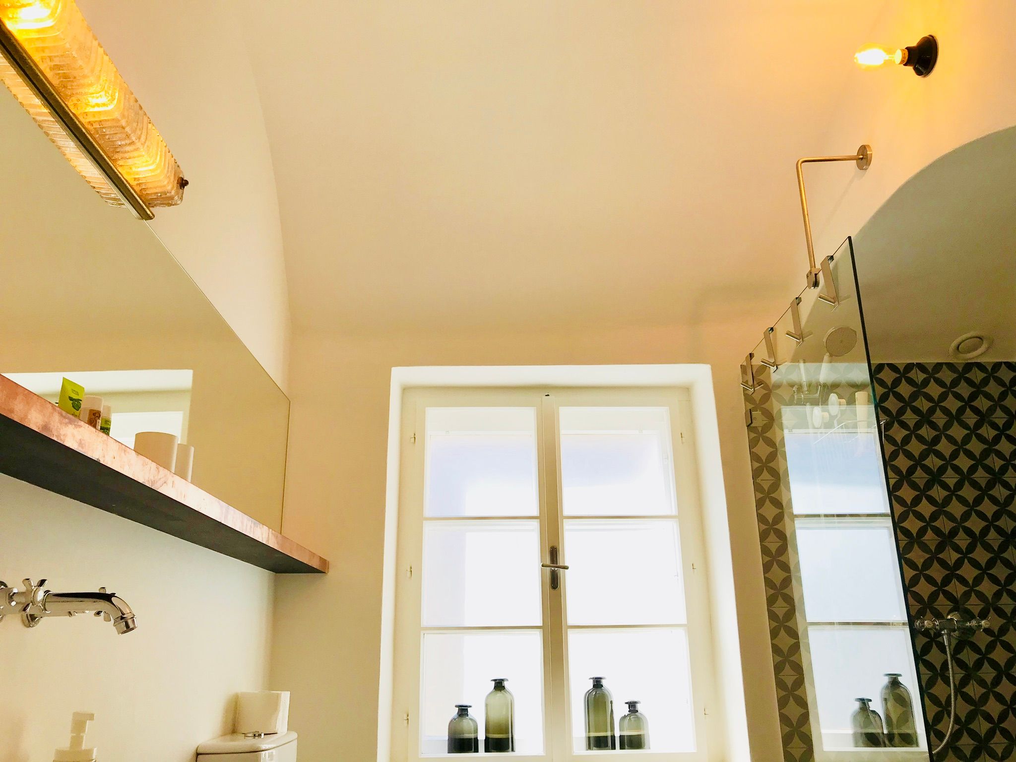 Modernes Badezimmer mit Glasdusche und dekorativen Fliesen.