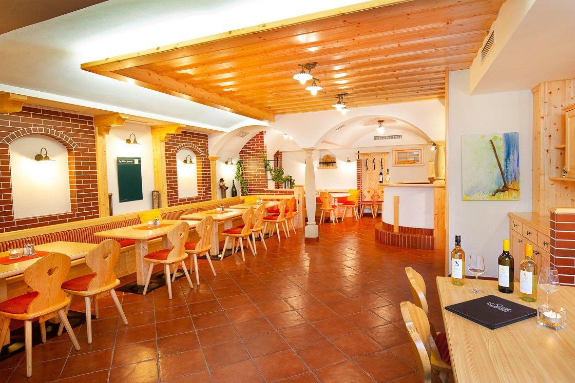 Gemütliches Restaurant mit Holzmöbeln und Ziegelwänden.