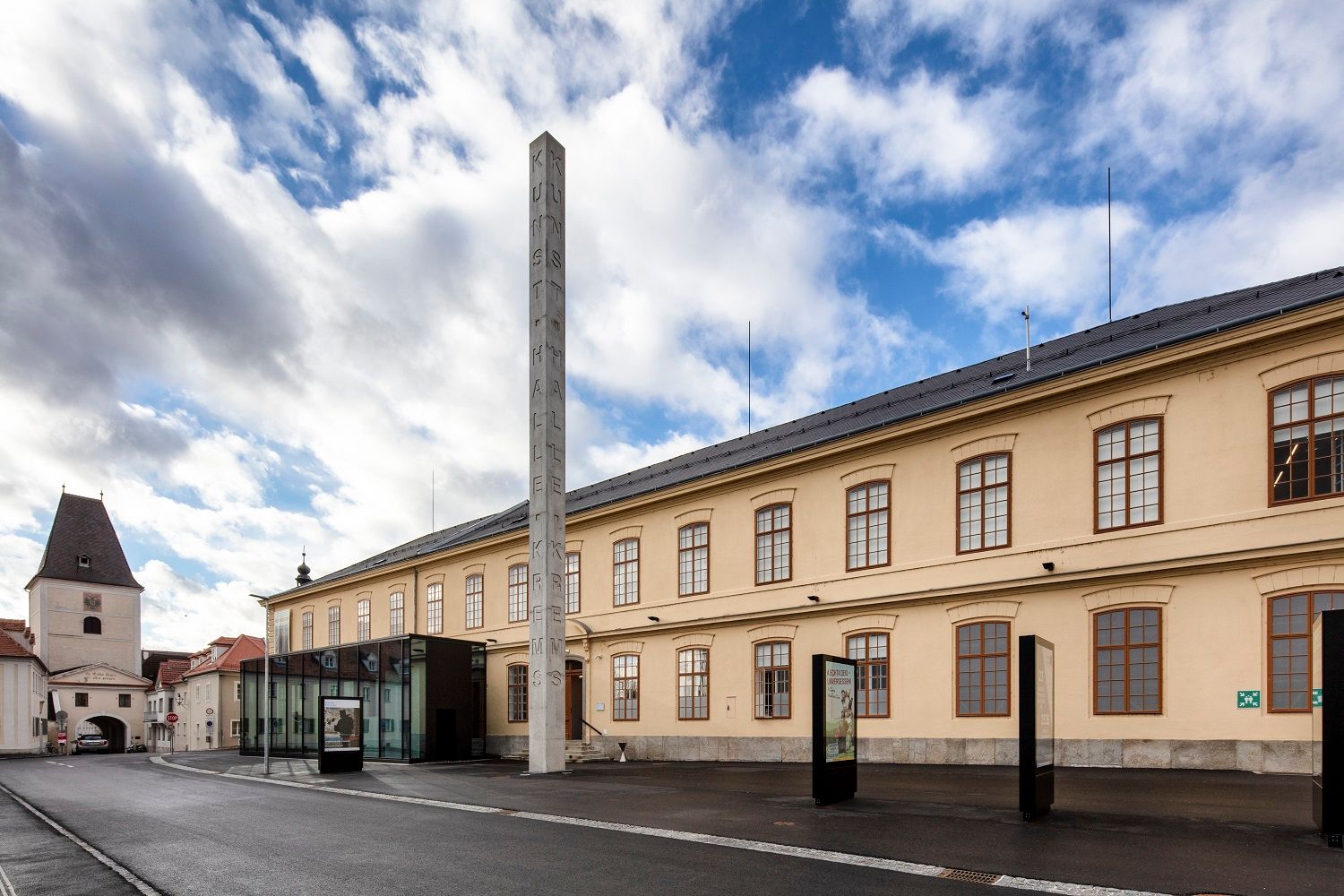 Außenansicht der Kunsthalle Krems mit Säule und blauem Himmel.