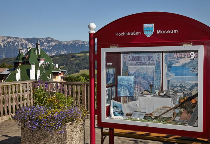 Schaukasten des Hochstraßenmuseums mit Berglandschaft im Hintergrund.