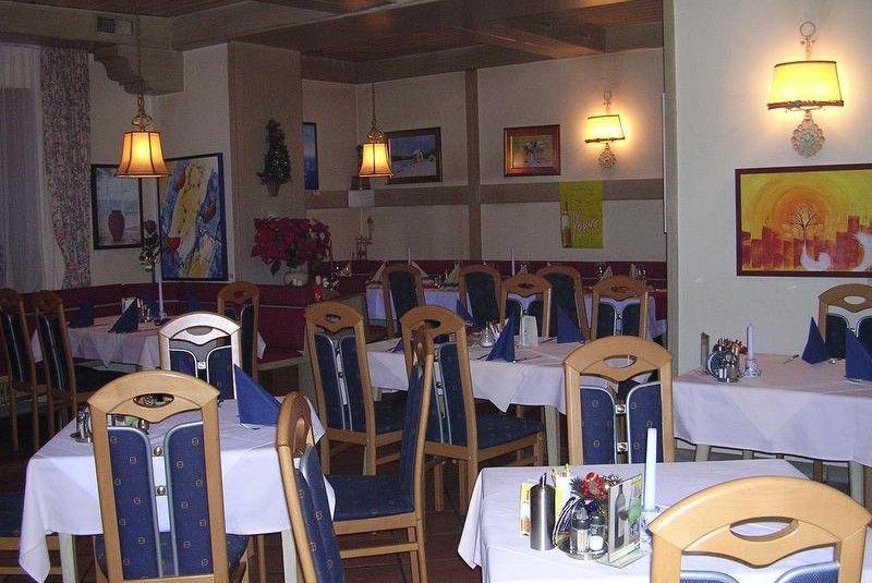 Ein gemütliches Restaurant mit Holzmöbeln, gedeckten Tischen und Wanddekorationen.