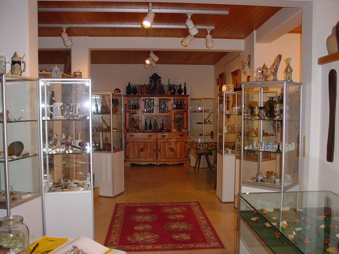 Innenansicht eines Museums mit Glasvitrinen voller Pfeifen und Sammlerstücke.