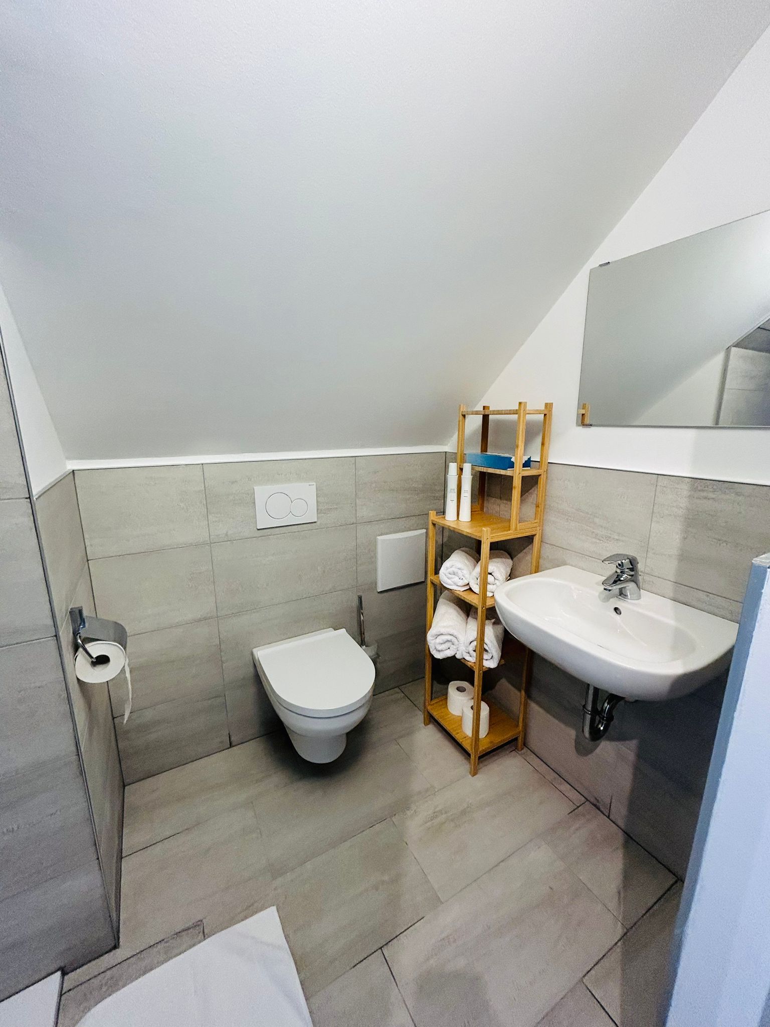 Badezimmer mit WC, Waschbecken und Dusche.