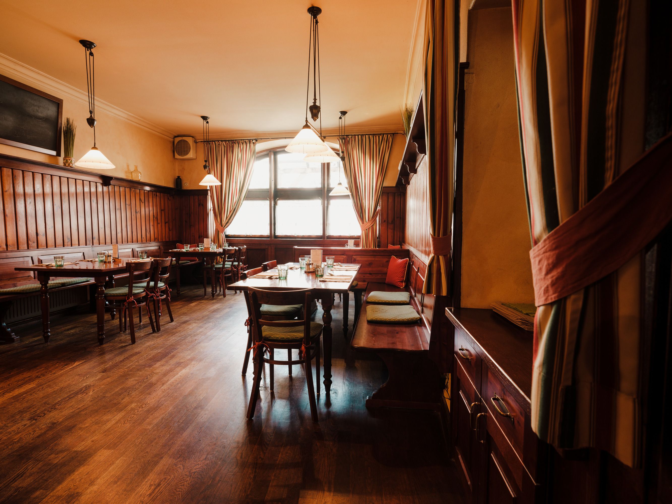 Gemütliches Restaurant mit Holzmöbeln und warmem Licht.