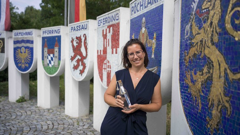 Frau steht vor Wappen am Nibelungendenkmal in P&ouml;chlarn.