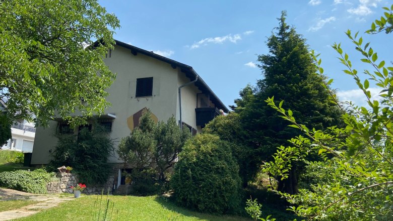 Privatzimmer Haus Köhler, © Wiener Alpen Ein zweistöckiges Haus mit Garten und Bäumen, bei sonnigem Wetter.