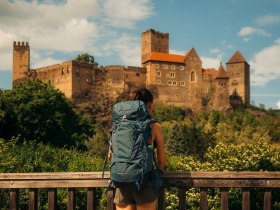 Wandererin, die zur malerischen Burg Hardegg schaut