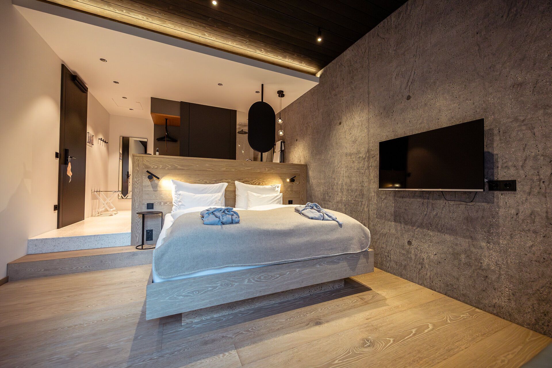 Innenansicht eines modernen Restaurants mit großen Fenstern und Blick auf bewaldete Hügel.