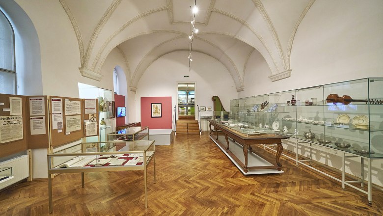 Innenansicht eines Museumsraums mit Vitrinen und Ausstellungsst&uuml;cken.