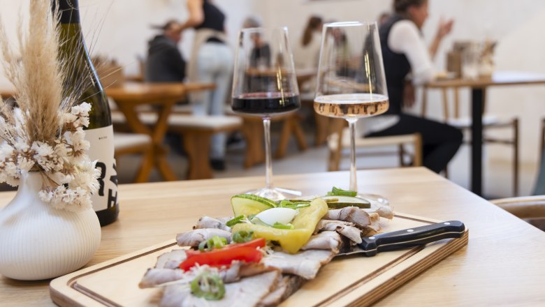 Heurigenjause, Weingl&auml;ser im Hintergrund Menschen