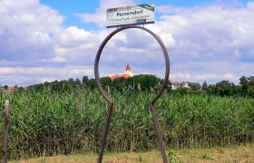 Blick durch eine Schlüsselform auf eine Kirche in Pernersdorf.