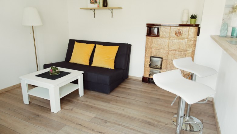 Modernes Wohnzimmer mit Sofa, Couchtisch, Barhockern und Kamin.