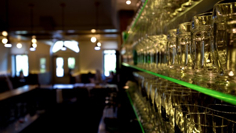 Regal mit Gl&auml;sern in einem Restaurant, unscharfer Hintergrund.