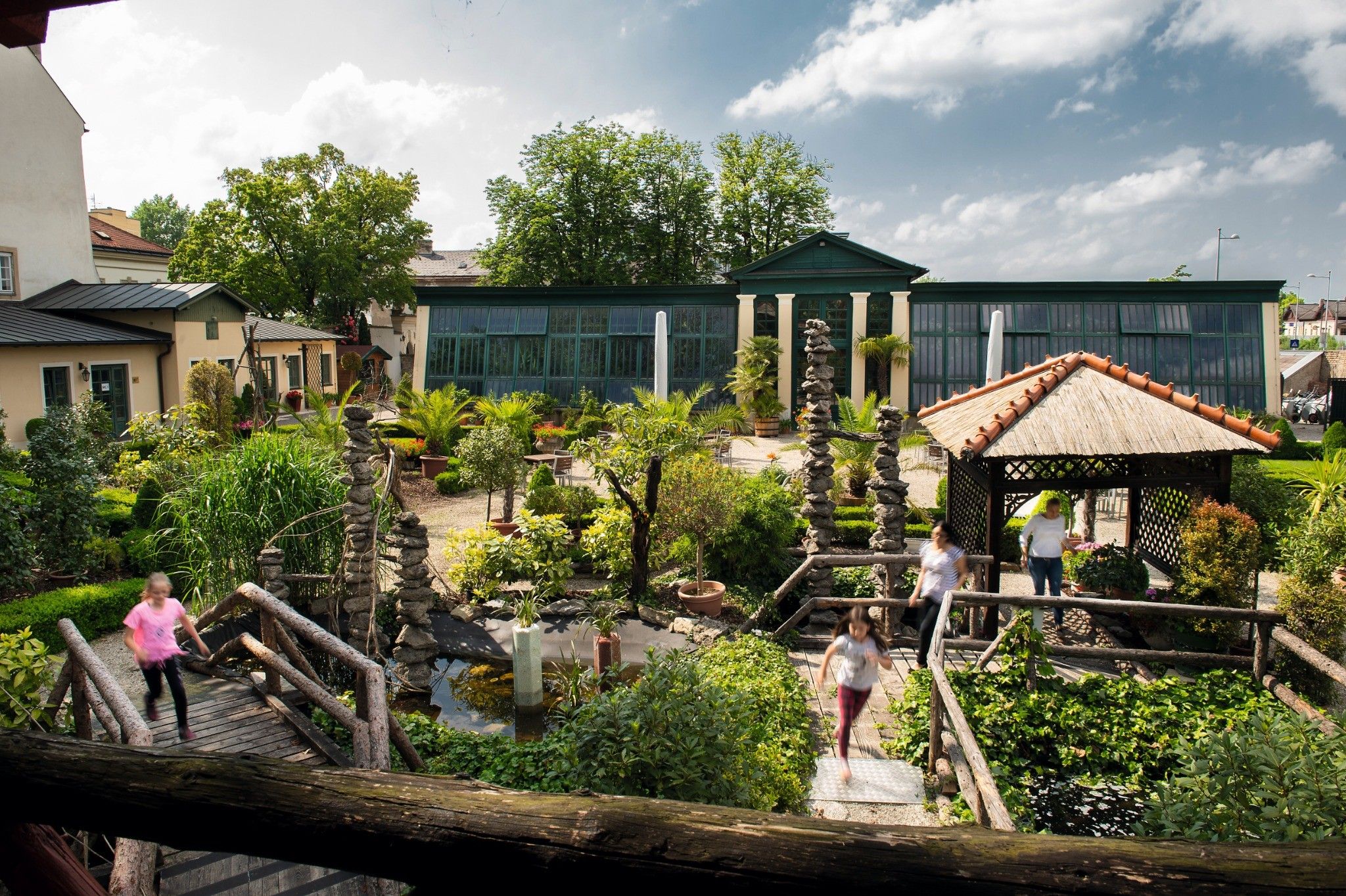 Ein Garten mit Holzbrücken, Pflanzen und einem Pavillon im Stift Klosterneuburg.