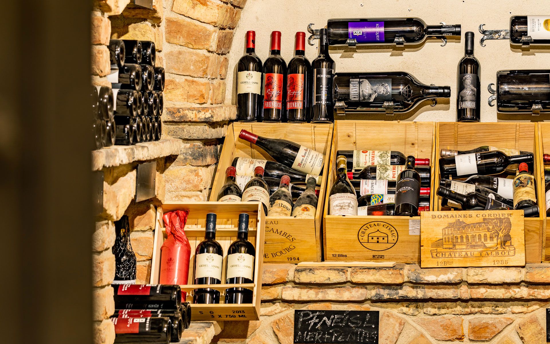 Weinflaschen in einem rustikalen Weinkeller mit Backsteinwänden.