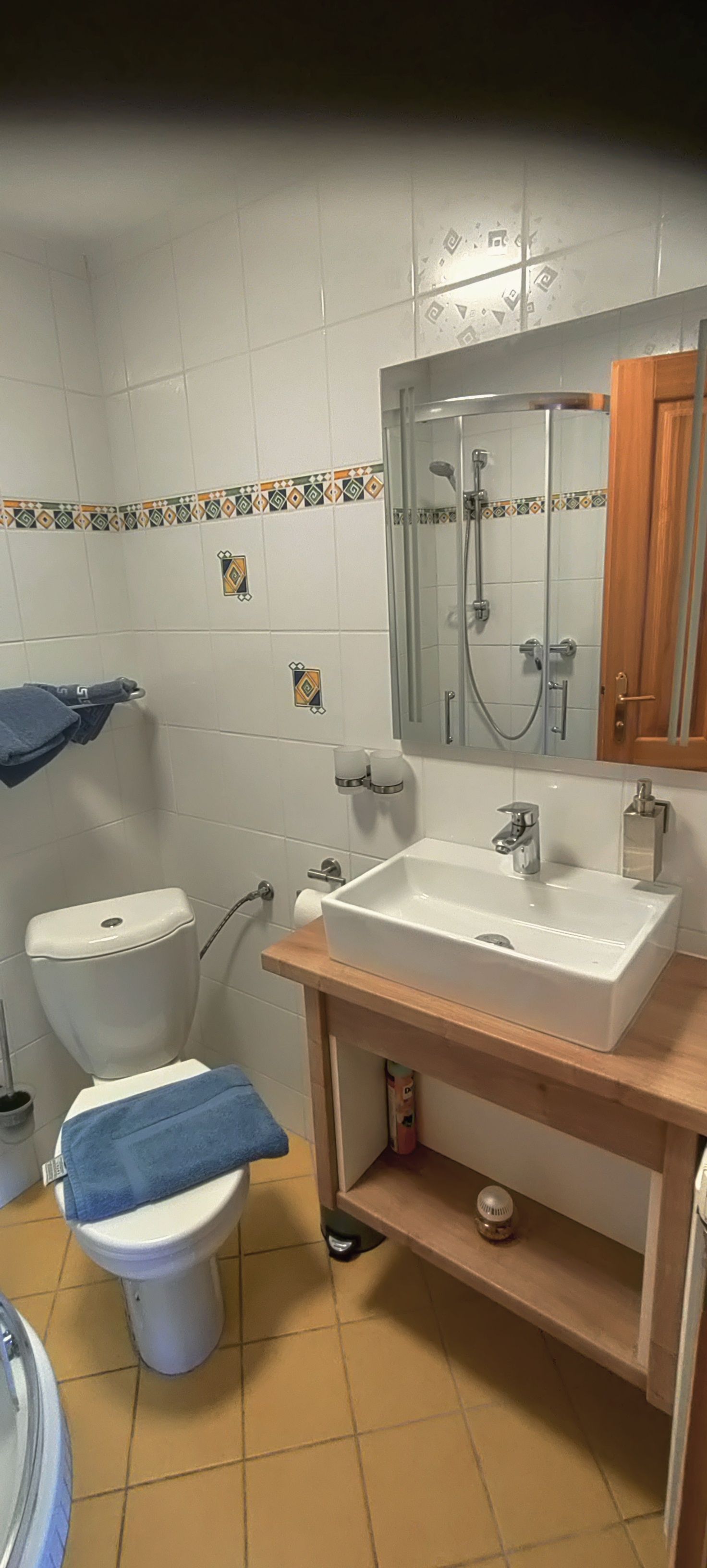 Kleines Badezimmer mit Toilette, Waschbecken und Spiegel.