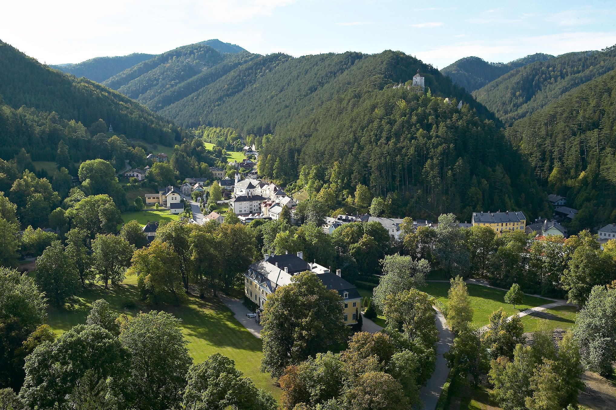 Luftaufnahme von Gutenstein mit grünen Hügeln und einem Schloss auf einem Hügel.