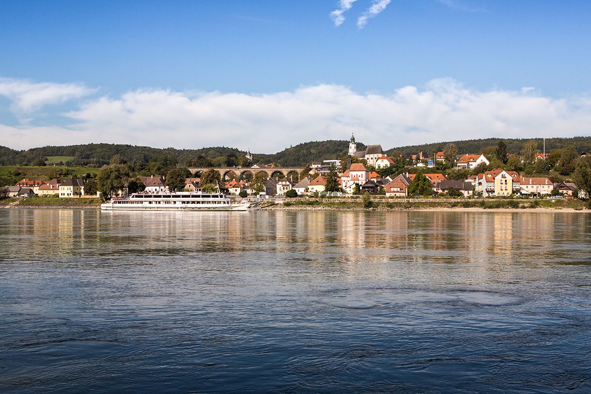 Panorama der Gemeinde Emmersdorf an der Donau mit einem Schiff auf dem Fluss.