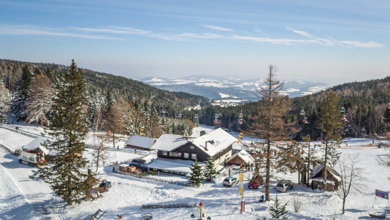 Winterlandschaft mit Berggasthof und Skilift in Mönichkirchen.