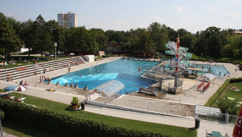 Freibad mit Schwimmbecken, Wasserrutsche und Liegewiese.