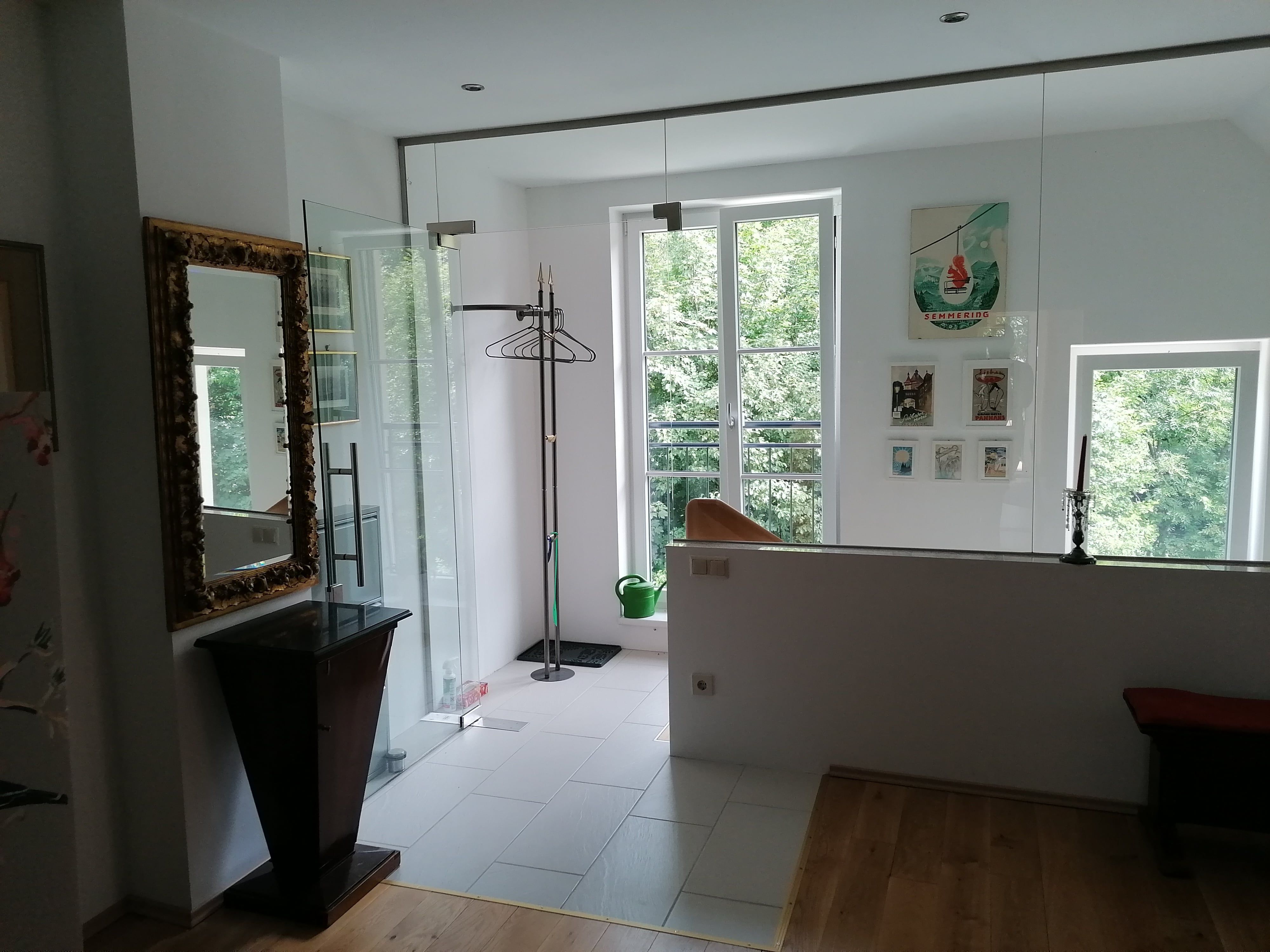 Eingangsbereich einer Ferienwohnung mit Spiegel, Kleiderständer und Bildern an der Wand.