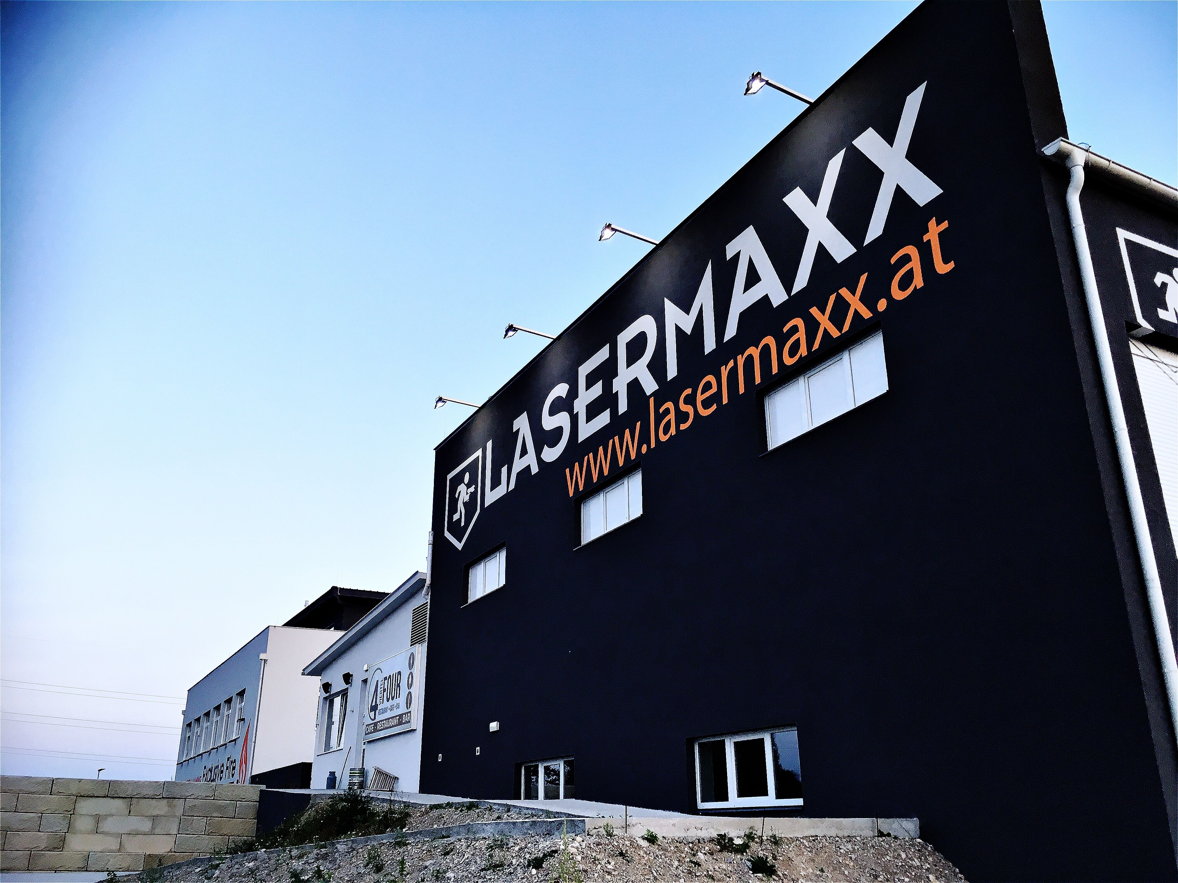 Gebäude mit großem Lasermaxx-Logo und Website-Adresse auf der Fassade.