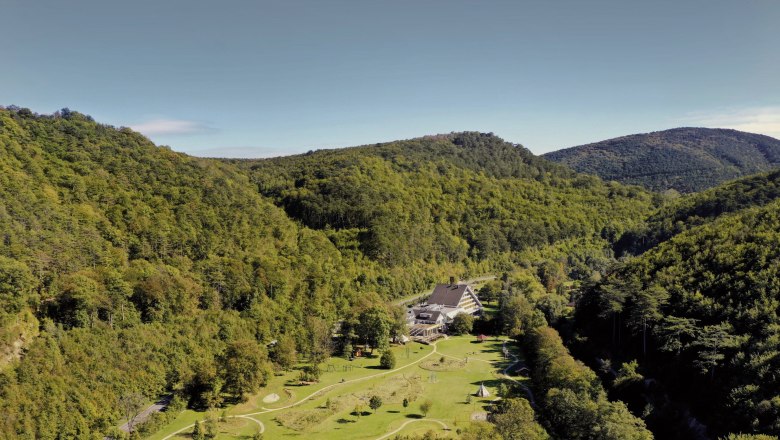 Luftaufnahme der Krainerhütte inmitten bewaldeter Hügel.