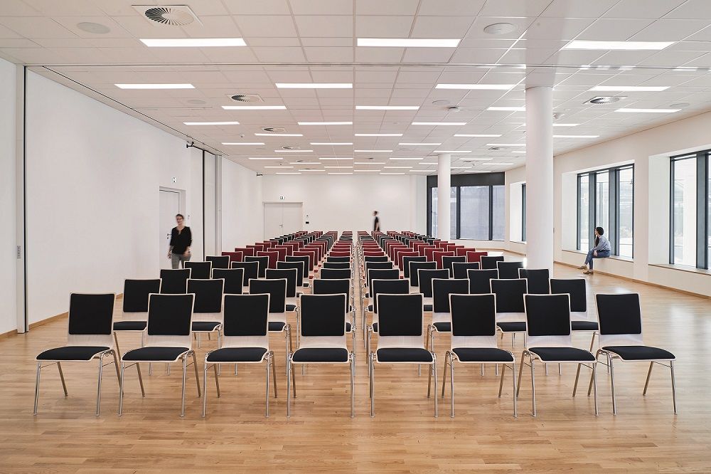 Leerer Konferenzraum mit Stuhlreihen und Holzfußboden.