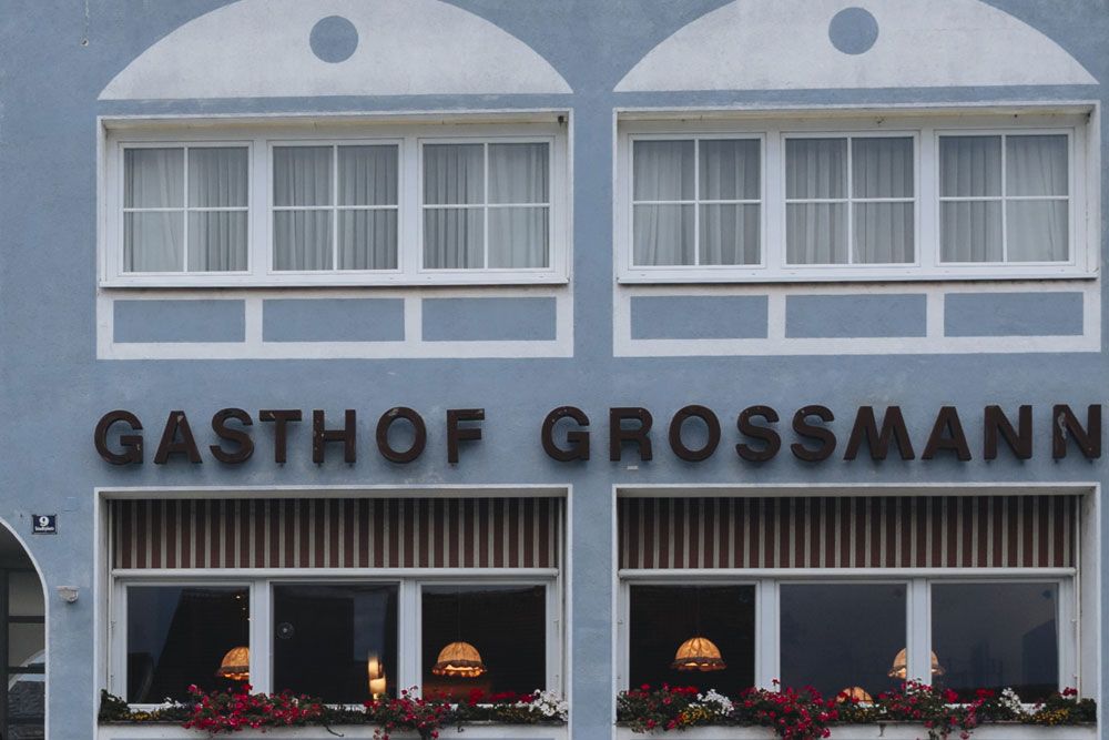 Fassade des Gasthofs Grossmann mit Fenstern und Blumenkästen.