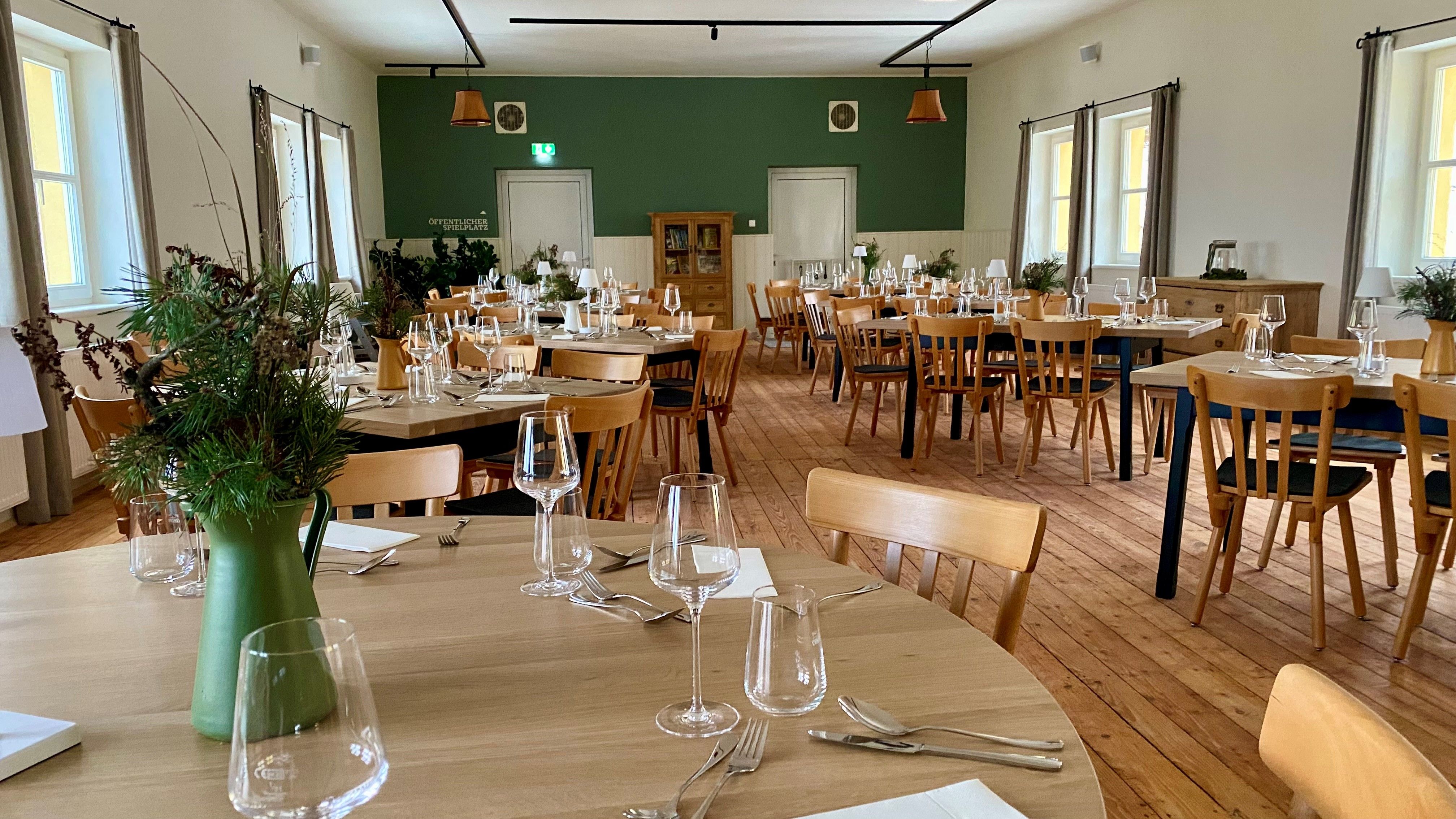 Moderner Saal im Obergeschoss des Gasthauses, mit original Holzboden, Holztischen- und Sesseln.