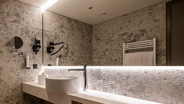 Modernes Badezimmer mit Waschbecken, Spiegel und Handtuchhalter.