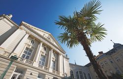 Das Stadttheater Baden bei Nacht, beleuchtet mit warmem Licht.