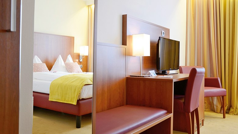 Doppelzimmer im Wachauerhof mit Bett, Schreibtisch, Fernseher und Stuhl.