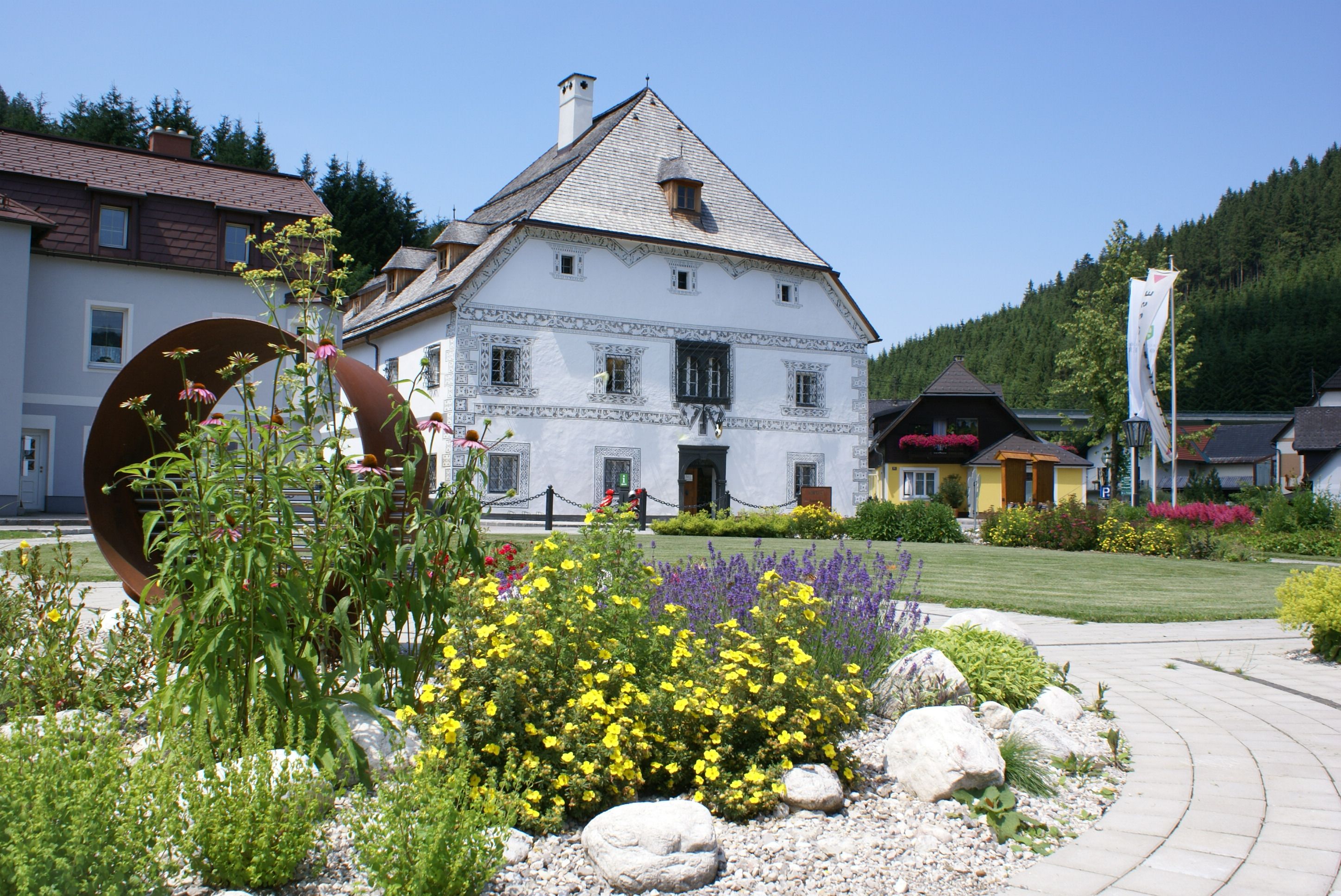 Historisches Gebäude mit Blumenbeet im Vordergrund in Lunz am See.