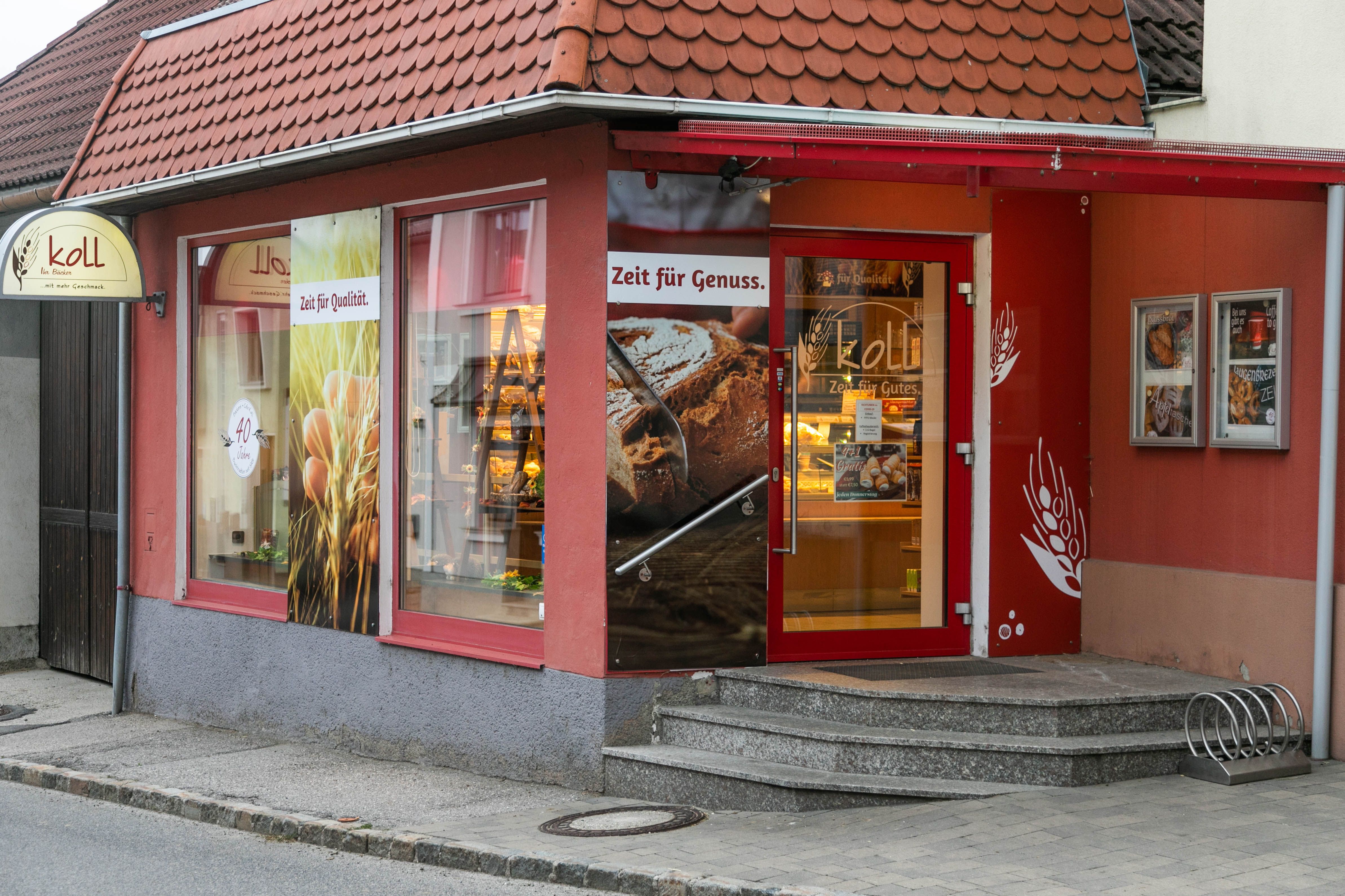 Eingang der Bäckerei mit Café in Wiesmath, mit roten Wänden und Schildern.