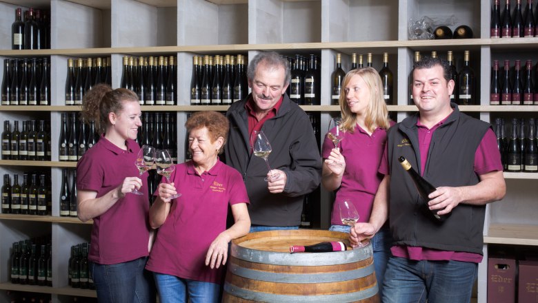 F&uuml;nf Personen in einem Weinkeller sto&szlig;en mit Weingl&auml;sern an.