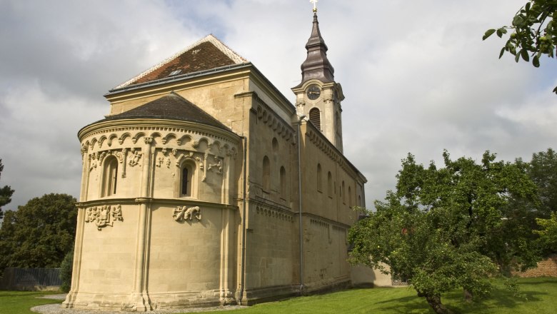 Romanische Kirche in Grabern mit Turm und grüner Wiese.