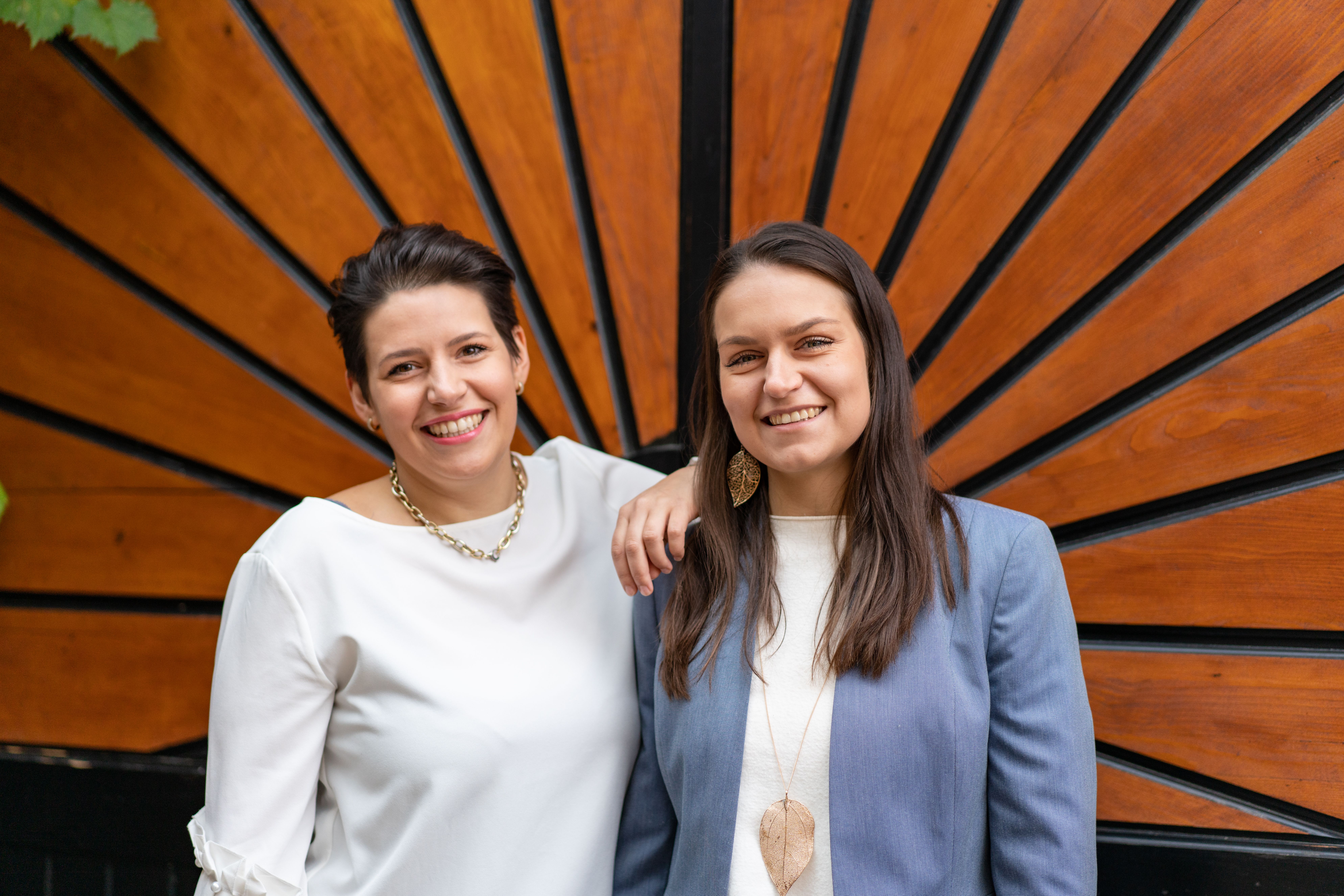 Gemütlicher Gartenbereich mit Holztisch und Stühlen, umgeben von Pflanzen und Weinreben.