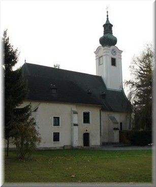 Kirche mit Turm und grünem Dach in Schwadorf.