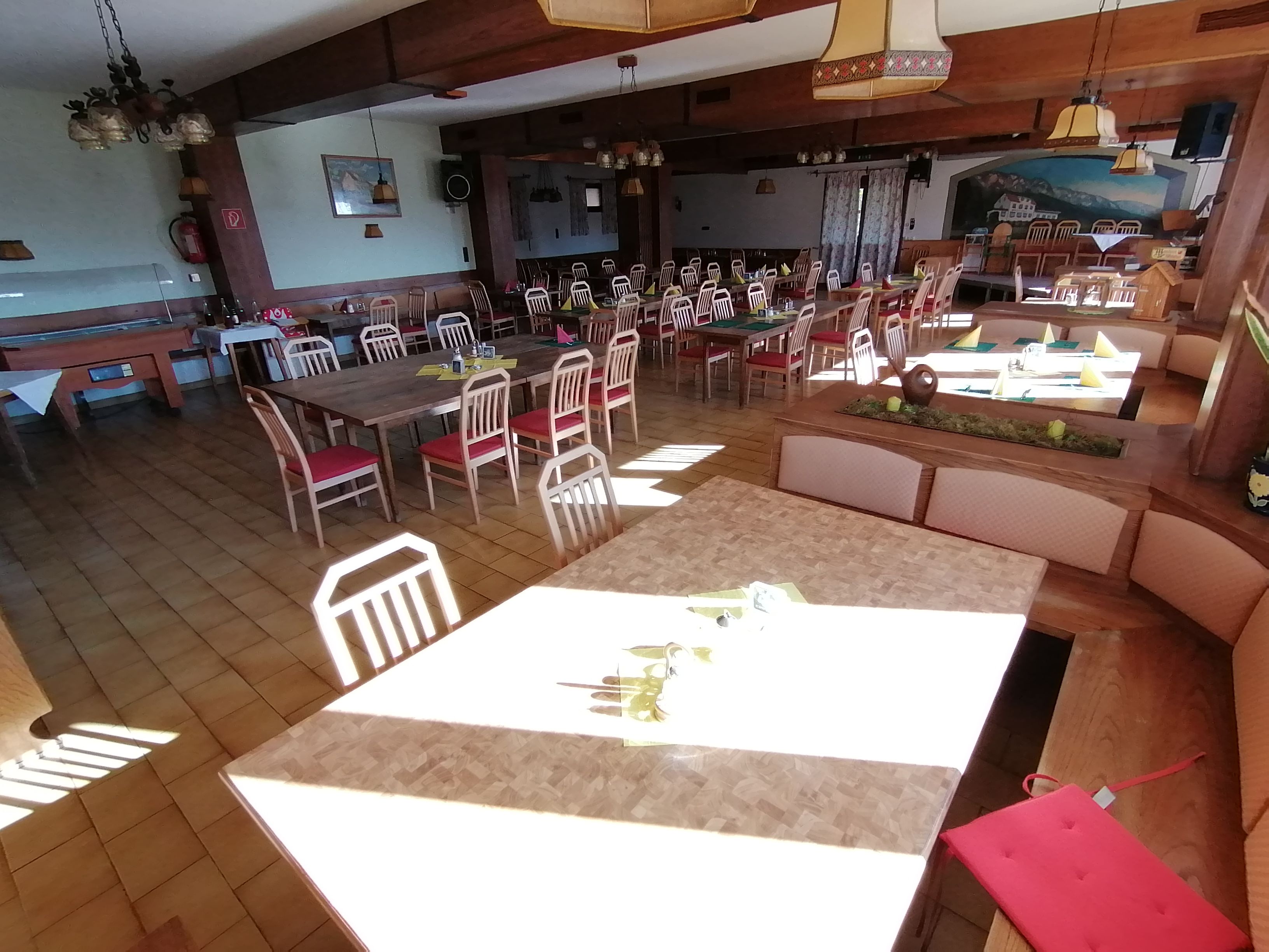 Ein leerer Speisesaal mit Holztischen und roten Stühlen im Gasthof Mohr.