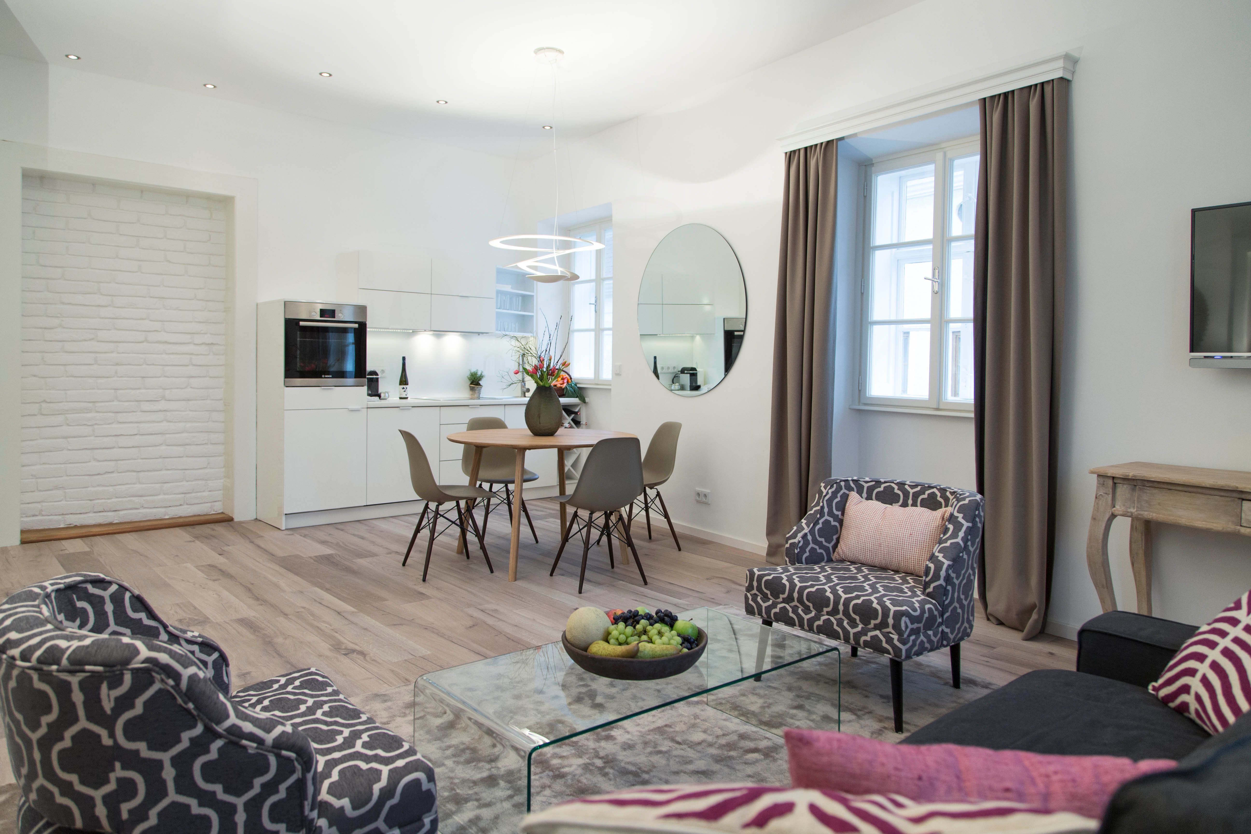 Modernes Wohnzimmer mit Küche, Esstisch und stilvollen Möbeln.