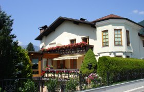 Weißes Haus mit Balkon und Blumen