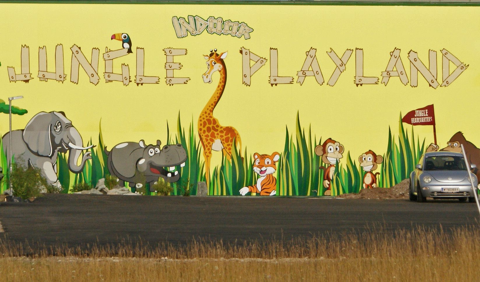 Wandbild mit Dschungeltieren und Schriftzug 'Jungle Playland'.