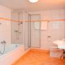 Modernes Badezimmer mit Badewanne, Dusche, Waschbecken und Toilette.